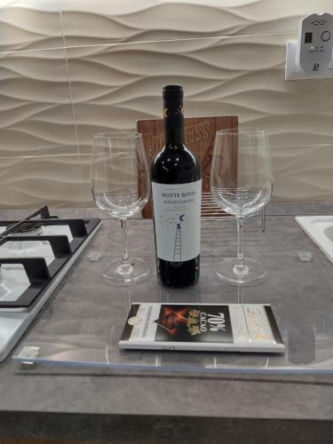 uma garrafa de vinho e dois copos de vinho numa mesa em Piccolo Paradiso in pieno centro Rivisondoli em Rivisondoli