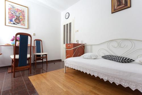 a bedroom with a bed and a table and a chair at Do you want to fully enjoy Old Town in Dubrovnik