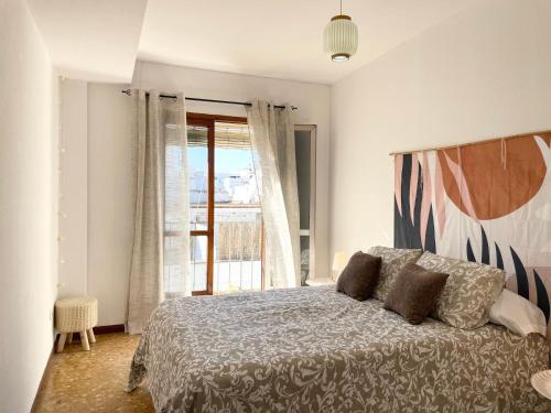 1 dormitorio con cama y ventana grande en Selva La Bella. En el Corazón de Triana, en Sevilla