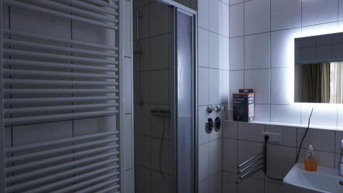 a white bathroom with a shower and a sink at Gasthaus Schöne Aussicht in Usingen