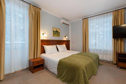a bedroom with a bed and a flat screen tv at Verevi Motel in Elva