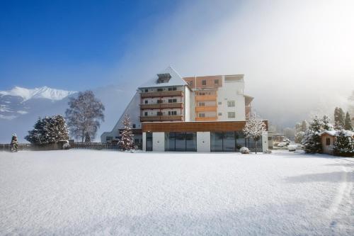 a building in the middle of a snow covered yard at Hotel Truyenhof in Ried im Oberinntal