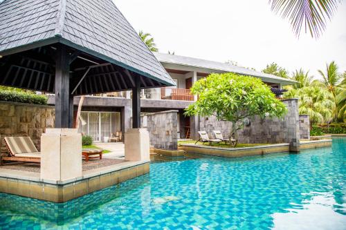 a villa with a swimming pool and a house at Mandarin Oriental, Sanya in Sanya