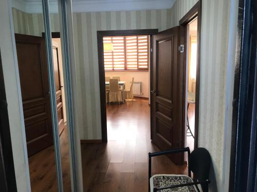 ein Flur mit Türen und ein Raum mit einem Tisch in der Unterkunft 1 комнатная квартира в самом центре города на Жарбосынова 71 in Atyrau