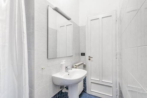ein weißes Badezimmer mit einem Waschbecken und einem Spiegel in der Unterkunft Studio Lavanda by Wonderful Italy in Turin