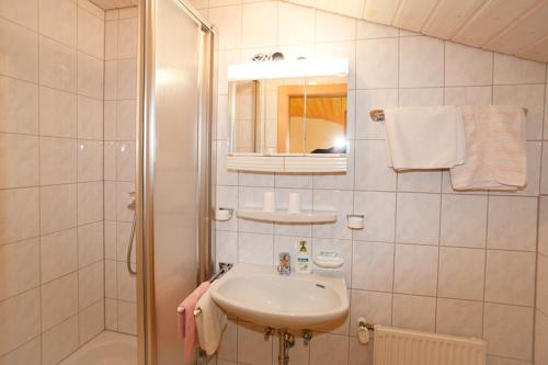 a white bathroom with a sink and a shower at Ferienwohnungen Plenk inkl. Chiemgaukarte in Ruhpolding