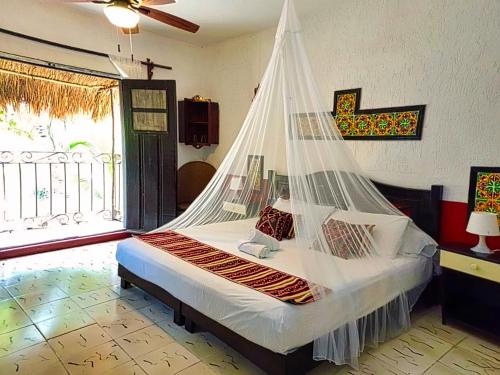 una camera da letto con un letto con una rete di Beachfront Apartment Hacienda del Cuyo a El Cuyo