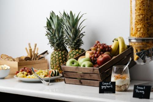 a table topped with boxes of fruits and vegetables at Cyano Hotel in Plakias