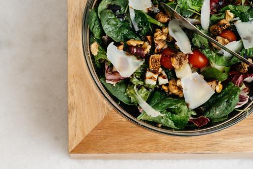 a salad in a bowl on a wooden cutting board at Cyano Hotel in Plakias