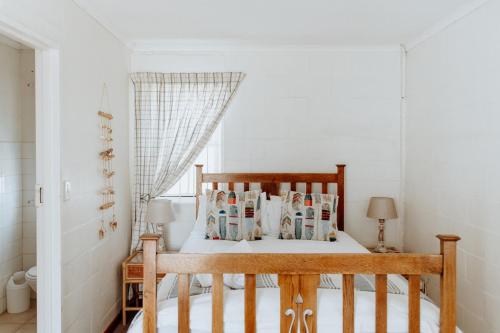 a bedroom with a wooden bed with magazines on it at In Betwix in Paternoster
