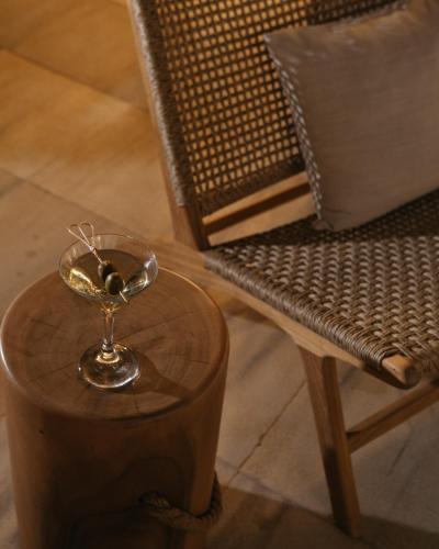 a glass bowl on a table next to a chair at Cyano Hotel in Plakias