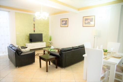a living room with two black couches and a tv at ABT Apartments Bonapriso-7Mins From Airport in Douala