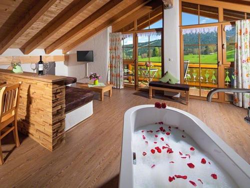 a living room with a bath tub with red flowers in it at Ferienwohnung Roislerlehen in Bischofswiesen