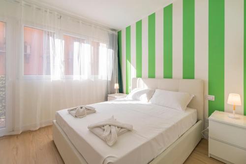 a bedroom with a bed with green and white stripes at Scarlatti Luxury apt. - B. Aires / Central Station in Milan