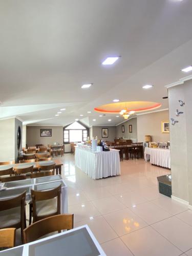Hotel Kent Ani في كارس: غرفة طعام مع طاولات وكراسي وكافتريا