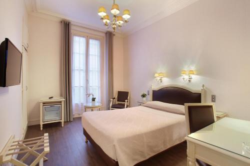 a bedroom with a large bed and a chandelier at HOTEL DU PRINTEMPS in Paris