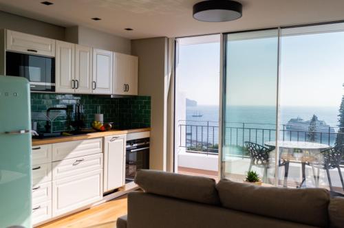 - une cuisine avec un canapé et une vue sur l'océan dans l'établissement Rooftop Funchal I by Madeira Best Apartments, à Funchal