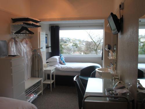 mały pokój z łóżkiem i oknem w obiekcie The Red House Guest House w mieście Falmouth