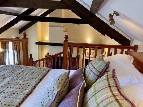 a bedroom with a bed with pillows on it at Rose Cottages in Alnwick