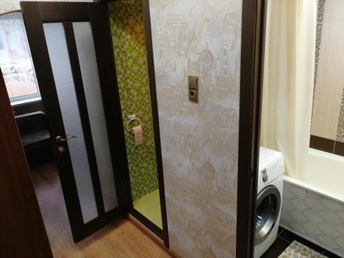 a shower with a glass door in a bathroom at "СКомфортом" однокомнатная квартира на Проспекте Мира 375 in Yuzhno-Sakhalinsk
