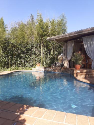 a swimming pool in a backyard with a gazebo at Stunning BnB in Gorgeous Garden Setting in Germiston