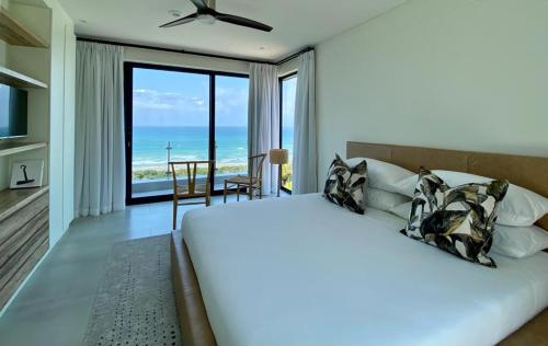 a bedroom with a bed with a view of the ocean at Heaven's Door in Trafalgar