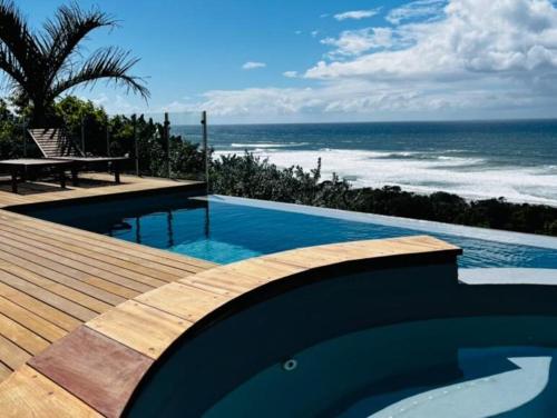 a swimming pool with a view of the ocean at Heaven's Door in Trafalgar