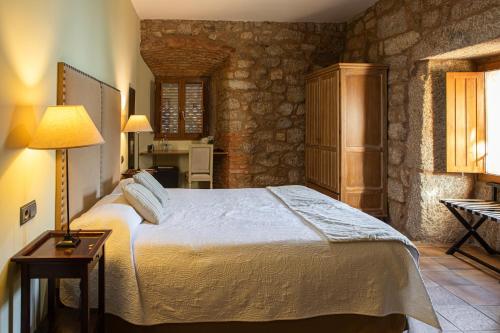 una camera da letto con un letto e un tavolo con una lampada di EL DUENDE DEL CHAFARIL a San Martín de Trevejo