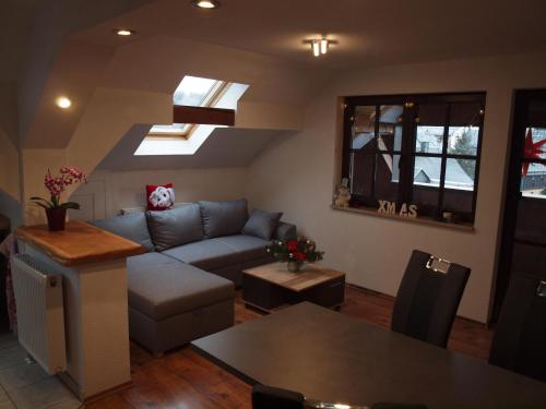 a living room with a couch and a table at Attraktive FeWo in Rosenthal am Rennsteig in Neundorf