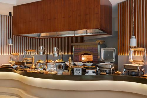a kitchen with a table with food and a fireplace at Ramada by Wyndham Dubai Barsha Heights in Dubai