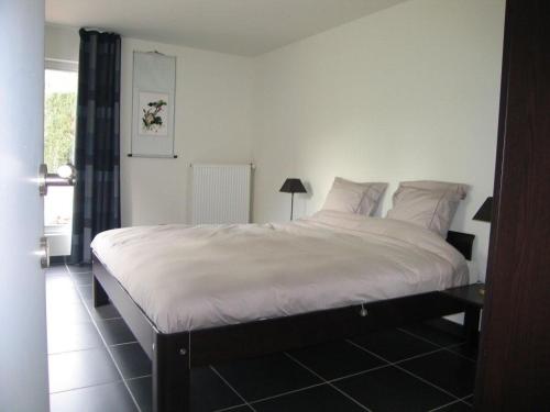 1 dormitorio con 1 cama grande con sábanas y almohadas blancas en Holiday Home and Office Domisi'l en Wachtebeke
