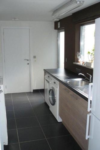 a kitchen with a sink and a washing machine at Holiday Home and Office Domisi'l in Wachtebeke