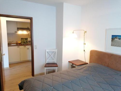 ヴェスターラントにあるSylter-Besserburg-App-2のベッドルーム1室(ベッド1台、テーブル付)、キッチン