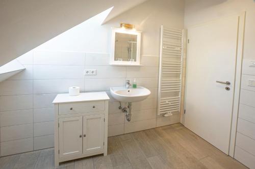 a bathroom with a sink and a mirror at Hirtenhaus 28b Obergeschoss in Chorin
