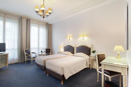 Cette chambre comprend deux lits et une télévision. dans l'établissement HOTEL DU PRINTEMPS, à Paris