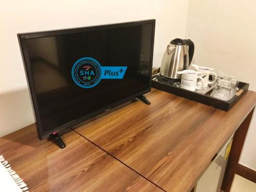 a flat screen tv sitting on top of a wooden table at Le Tanjong House in Patong Beach