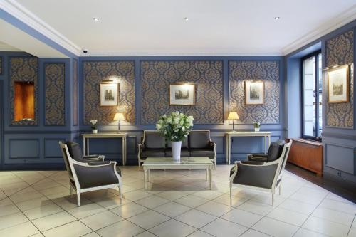 a waiting room with chairs and a table and flowers at HOTEL DU PRINTEMPS in Paris