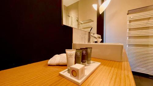 a bathroom with a sink and a counter withbranded products at Parkhotel du Sauvage in Meiringen