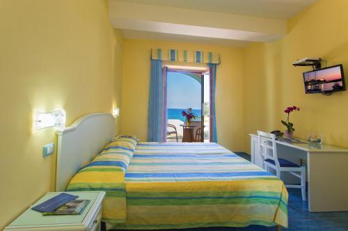 a hotel room with a bed and a view of the ocean at Hotel Cava Dell'Isola in Ischia