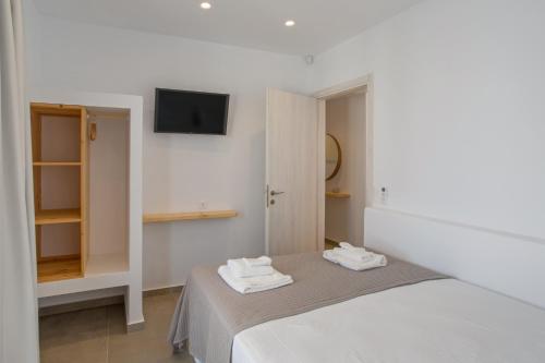a bedroom with a bed and a tv on the wall at Barbarigos luxury spa apartments in Naousa