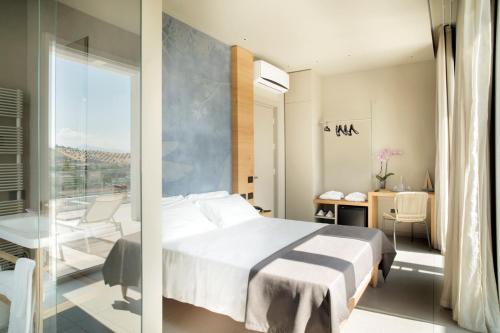 サン・ベネデット・デル・トロントにあるHotel Bernardのベッドルーム1室(ベッド1台、バルコニー付)の写真2枚