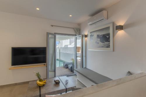 a living room with a flat screen tv on a wall at Barbarigos luxury spa apartments in Naousa