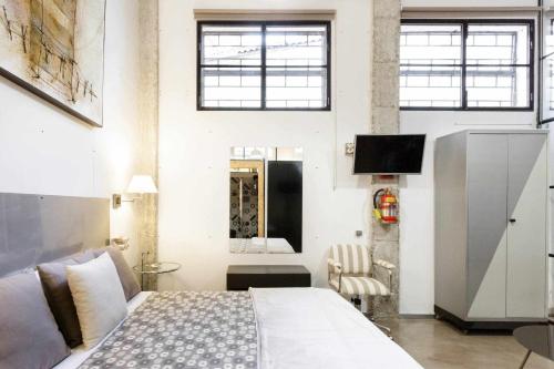 1 dormitorio con 1 cama y TV en una habitación en MonKeys Apartments Luxury MetaLoft, en Sevilla