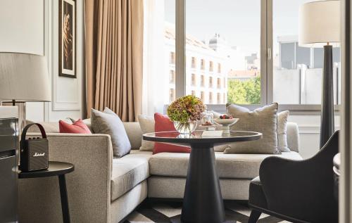 a living room with a couch and a table at Rosewood Villa Magna in Madrid