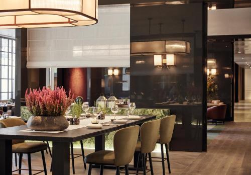 a dining room with a long table and chairs at Rosewood Villa Magna in Madrid