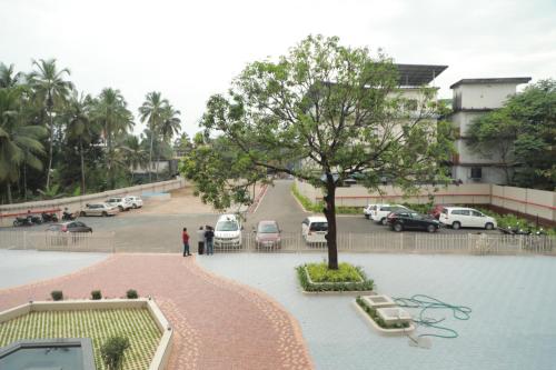 a view of a parking lot with a tree at Magnet Hotel in Kannur