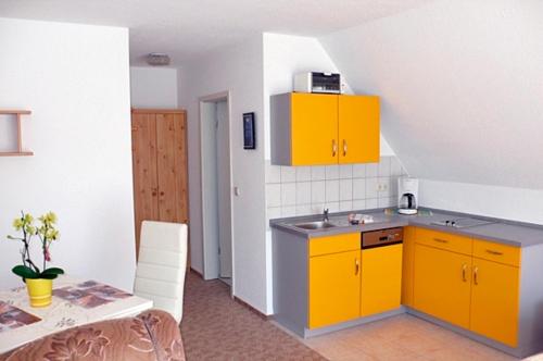a kitchen with yellow cabinets and a table at Wolf, Barbara, App1 in Zingst