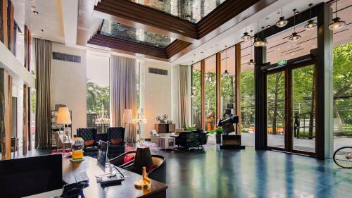 a large lobby with a large room with glass doors at Hotel Indigo Bangkok Wireless Road by IHG in Bangkok