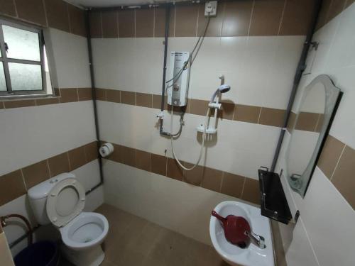 a bathroom with a toilet and a sink and a shower at Homstay Cameron Highlands in Cameron Highlands