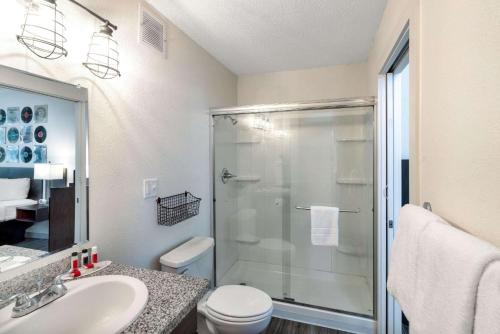 a bathroom with a shower and a toilet and a sink at Hillside Crossing Nashville a Ramada by Wyndham in Nashville